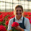 Retrato de una agricultora sonriente, María Rosales, en su invernadero de flores.
